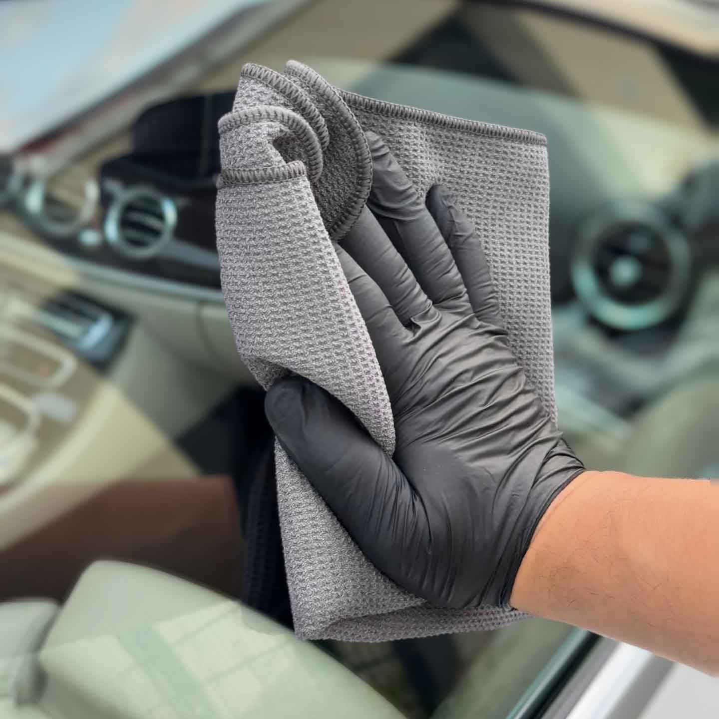 evorilo Hydro Waffle Glas Waffeltuch 320 GSM reinigt Autoglas mit grauer, texturierter Oberfläche und schwarzem Handschuh.